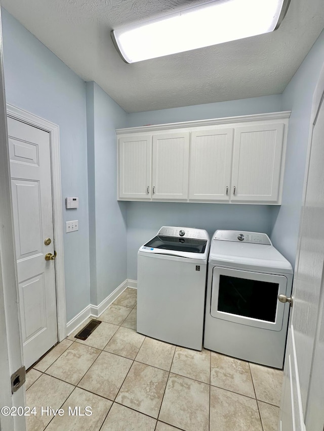 laundry room with cabinets, separate washer and dryer, and light tile patterned floors