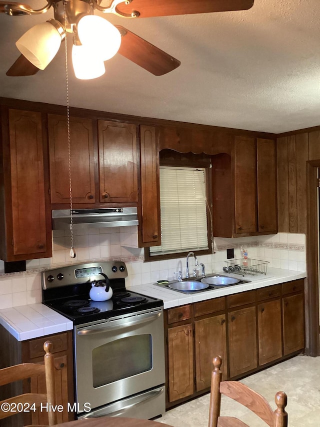 kitchen with electric stove, sink, and tasteful backsplash