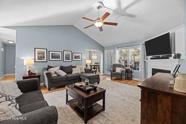 living room featuring ceiling fan, light hardwood / wood-style flooring, and lofted ceiling