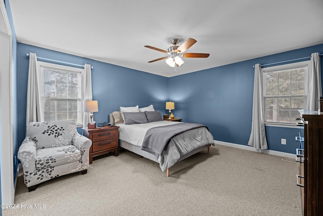 carpeted bedroom with ceiling fan and multiple windows