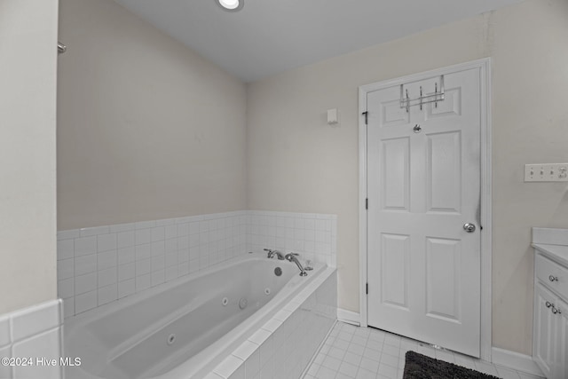 bathroom with tile patterned floors, tiled bath, and vanity