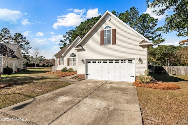 view of property with a garage and a front lawn