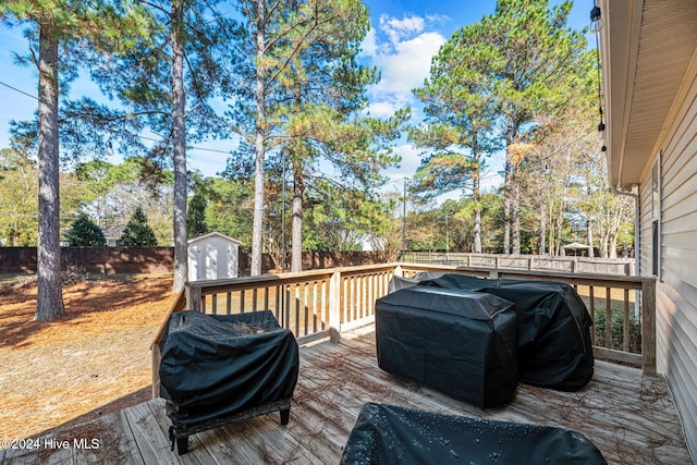 wooden deck with grilling area and a shed