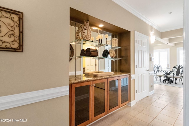 bar with crown molding and light tile patterned flooring