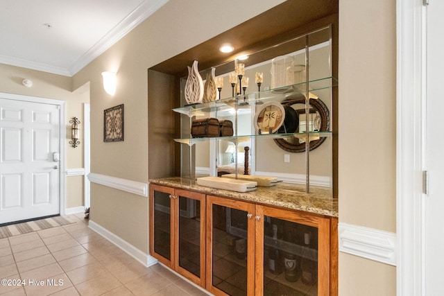 bar with light stone countertops, light tile patterned floors, and crown molding