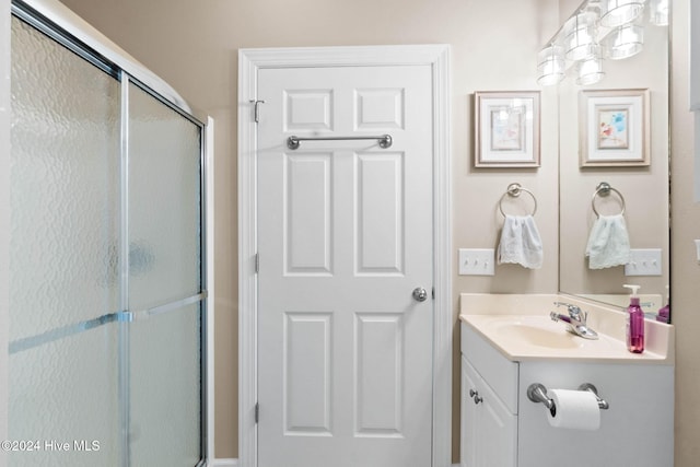 bathroom with vanity and a shower with door