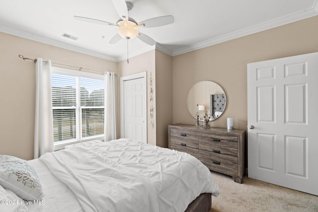 bedroom with ceiling fan, a closet, light colored carpet, and ornamental molding