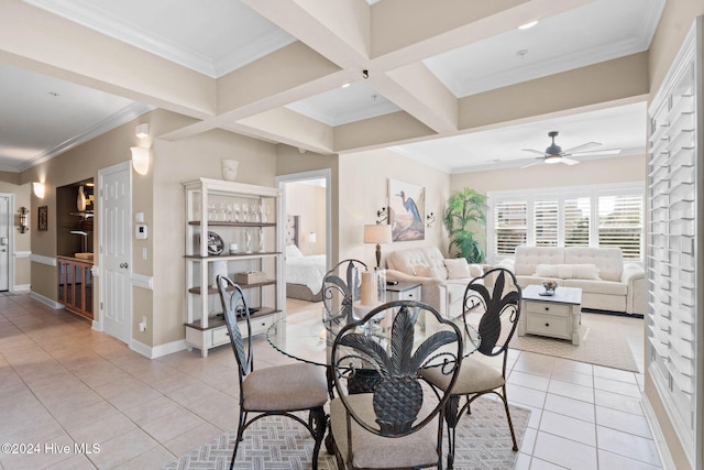 tiled dining area featuring ceiling fan, beam ceiling, crown molding, and coffered ceiling