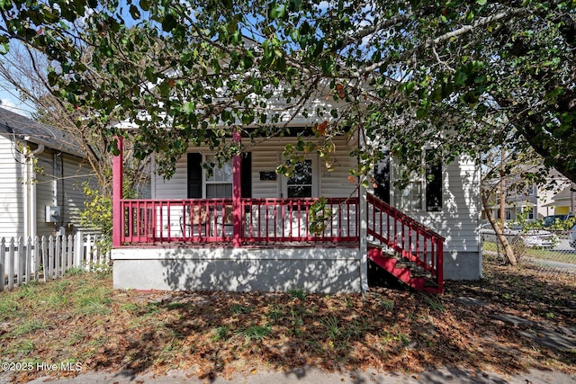 view of property hidden behind natural elements with a porch