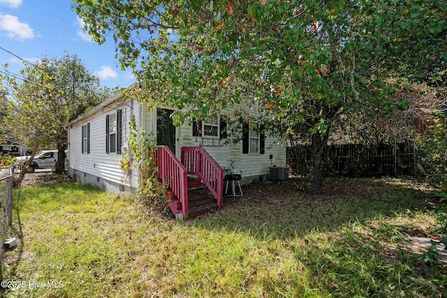 view of front of property with central AC and a front yard