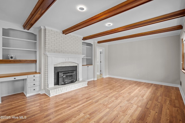 unfurnished living room with beamed ceiling, built in desk, built in features, and light hardwood / wood-style flooring