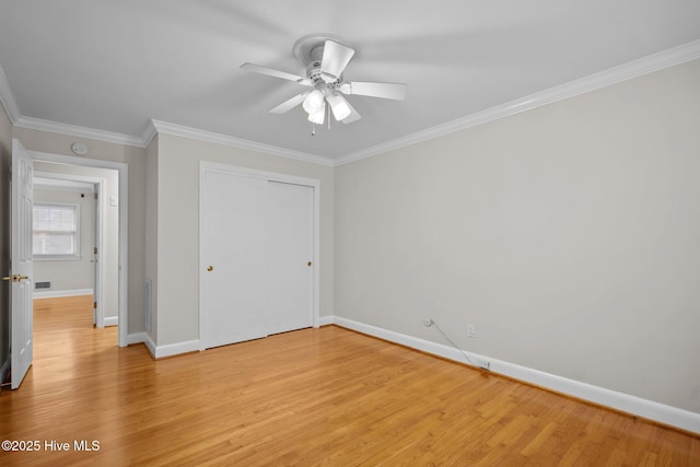 unfurnished bedroom with a closet, light hardwood / wood-style flooring, ceiling fan, and crown molding