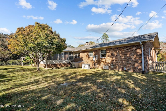 back of house with a sunroom and a yard