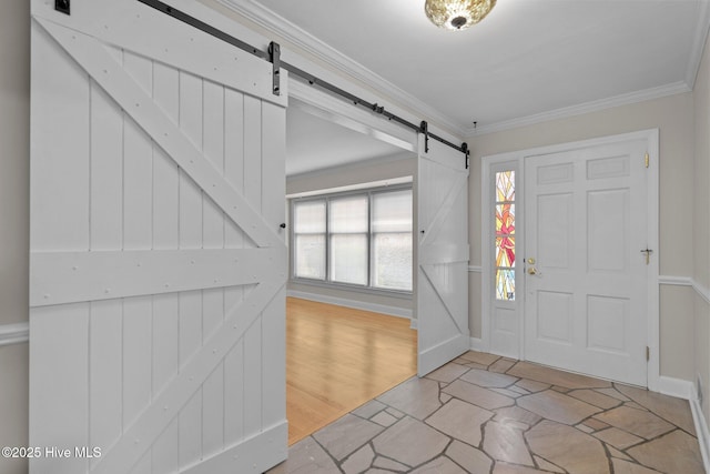 foyer featuring a barn door, a healthy amount of sunlight, and crown molding