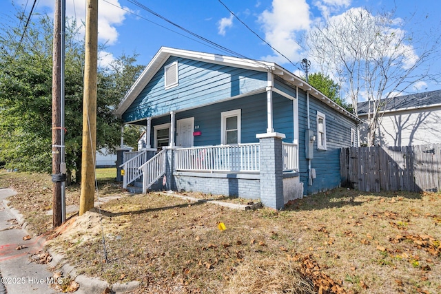 bungalow-style home with covered porch and a front yard