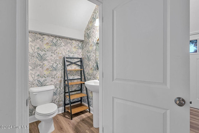 bathroom with hardwood / wood-style floors, toilet, and vaulted ceiling