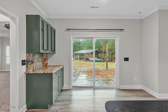 interior space featuring a wealth of natural light, crown molding, and light hardwood / wood-style flooring