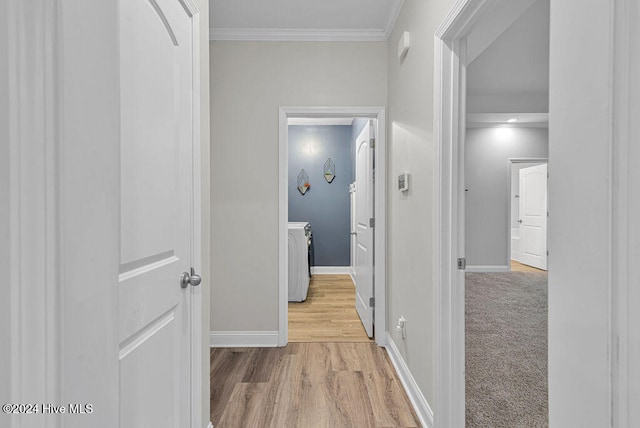 corridor with washer / clothes dryer, light hardwood / wood-style flooring, and crown molding