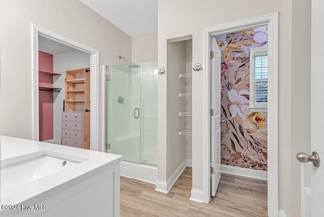 bathroom featuring hardwood / wood-style floors, vanity, and walk in shower