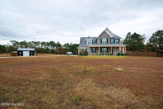 view of front of home featuring a front yard, a porch, and an outdoor structure