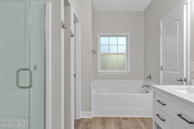 bathroom with independent shower and bath, vanity, and wood-type flooring