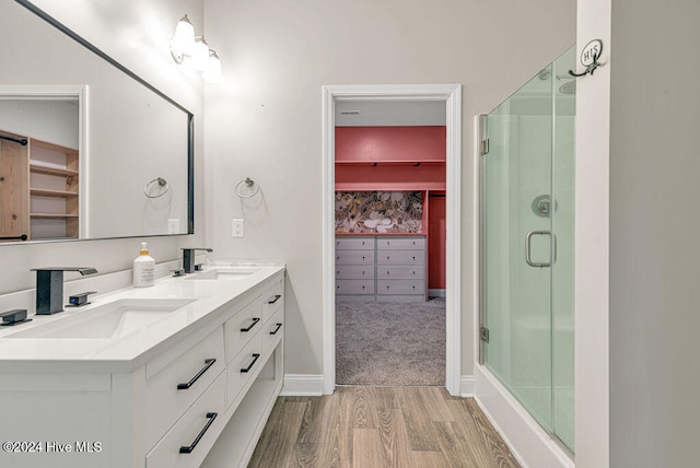 bathroom with hardwood / wood-style flooring, vanity, and a shower with shower door