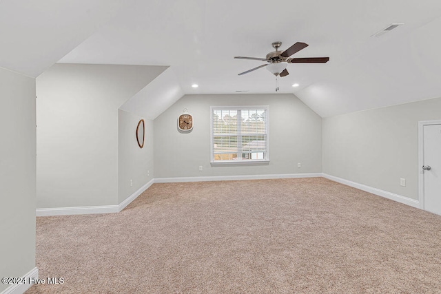 additional living space featuring ceiling fan, light carpet, and vaulted ceiling