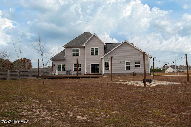 back of property with a lawn and a wooden deck