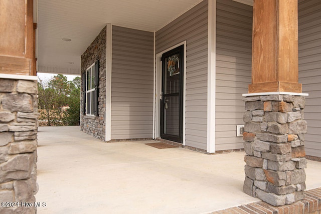 view of exterior entry featuring covered porch