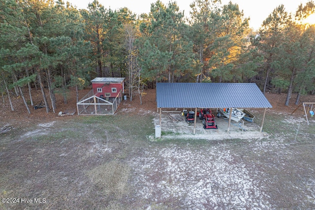 yard at dusk with a carport and an outdoor structure