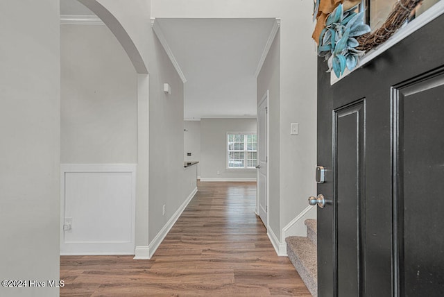 entryway with hardwood / wood-style floors and ornamental molding