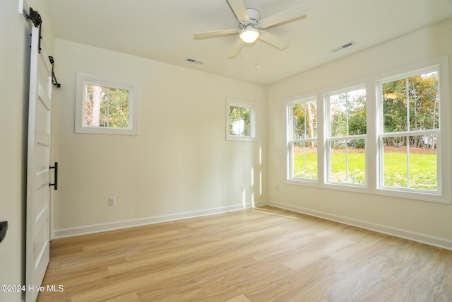 empty room with light hardwood / wood-style floors, ceiling fan, and plenty of natural light