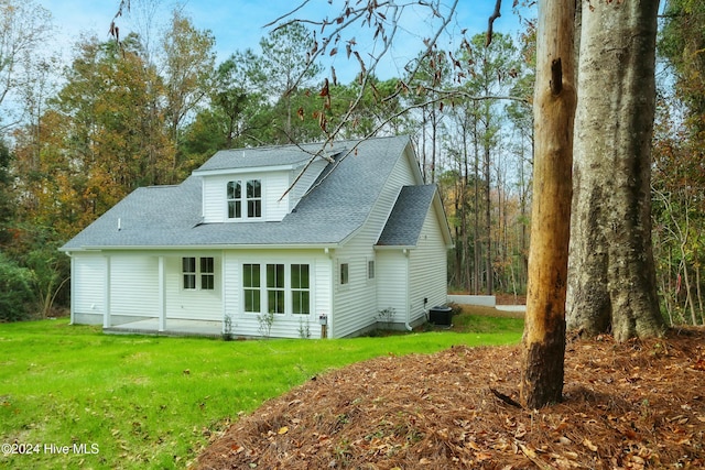 rear view of house with a yard and central AC