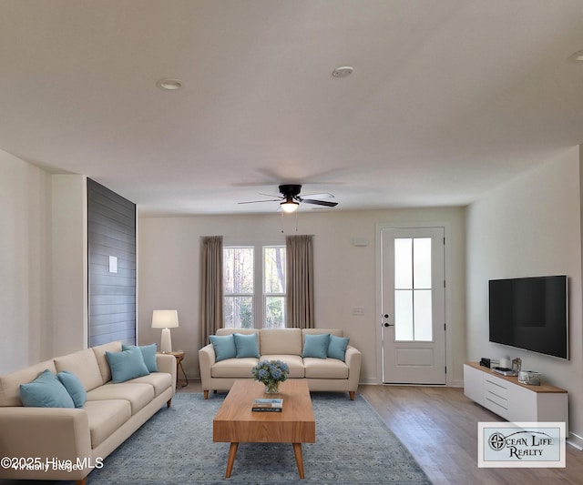 living room featuring ceiling fan and light hardwood / wood-style flooring