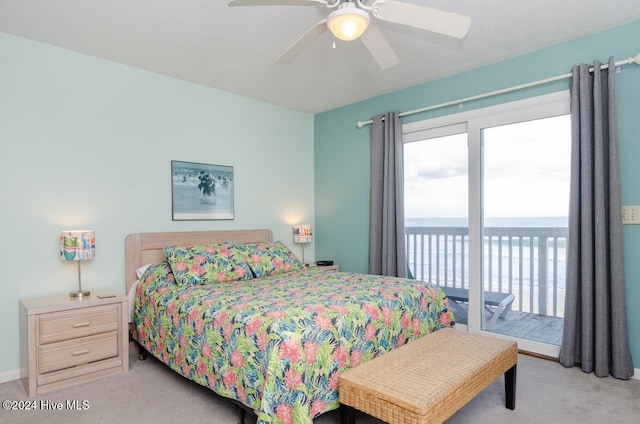 bedroom with light carpet, access to outside, ceiling fan, and a water view