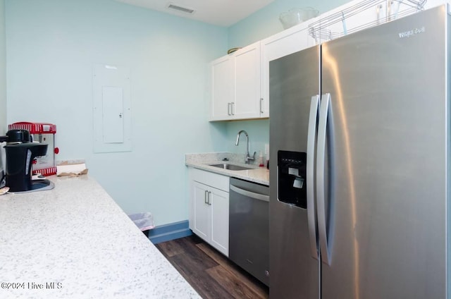 kitchen featuring sink, light stone countertops, dark hardwood / wood-style flooring, white cabinetry, and stainless steel appliances