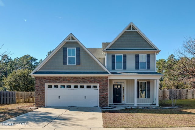 craftsman-style house with covered porch, a garage, and a front lawn