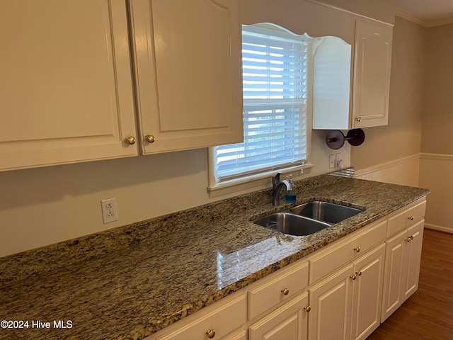 kitchen featuring stone counters, white cabinetry, sink, and dark hardwood / wood-style floors