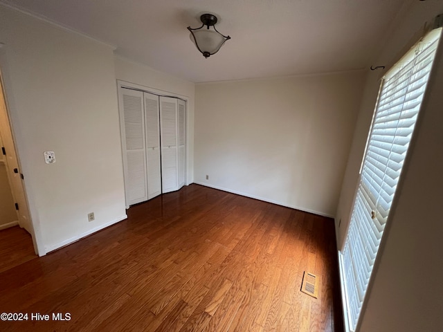 unfurnished bedroom with a closet and hardwood / wood-style floors