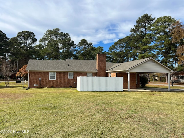 rear view of house with a yard and a carport