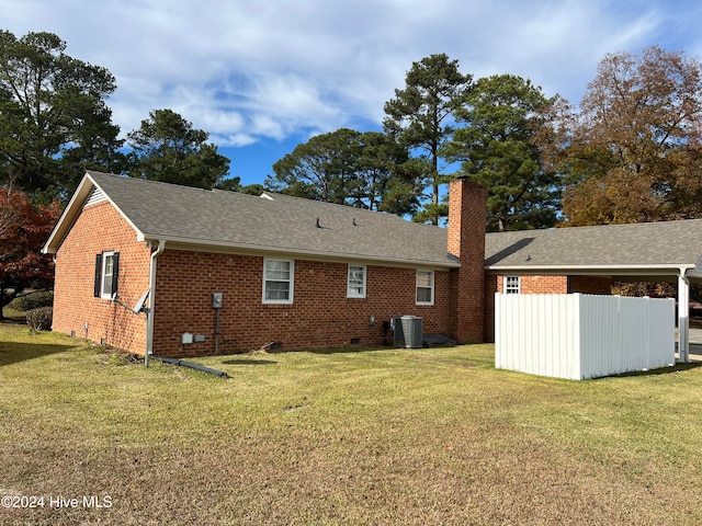 back of property featuring a yard and central AC unit