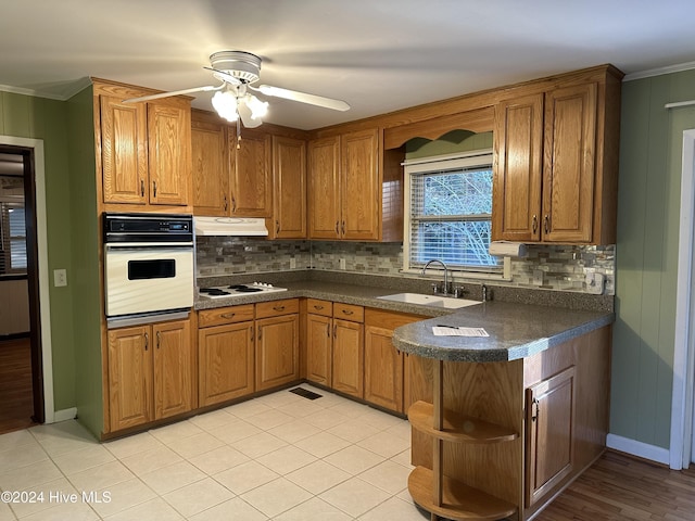 kitchen with sink, decorative backsplash, ornamental molding, ceiling fan, and white appliances