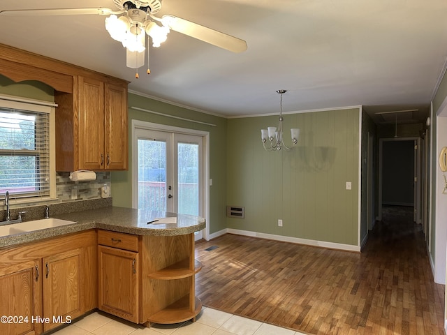 kitchen featuring light tile patterned flooring, sink, crown molding, hanging light fixtures, and kitchen peninsula