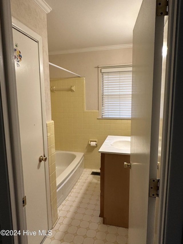 full bath featuring a wainscoted wall, crown molding, tile walls, bathtub / shower combination, and vanity