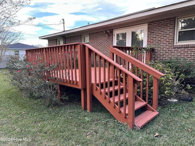 wooden terrace featuring a lawn