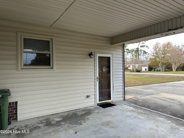 view of exterior entry with a patio