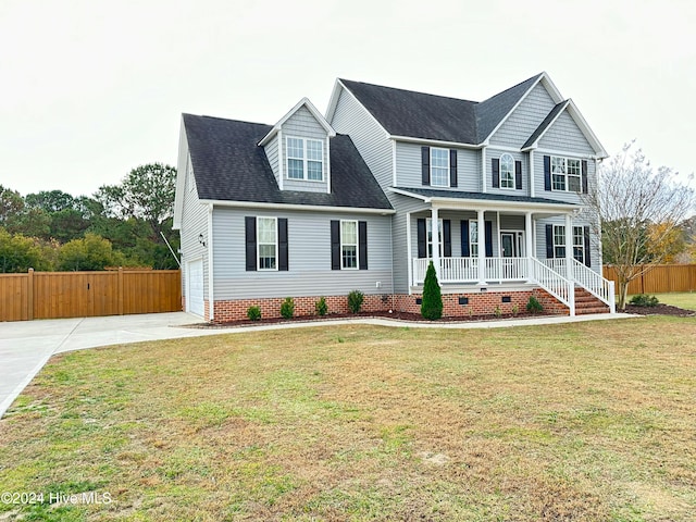 view of front of home with covered porch, a garage, and a front yard