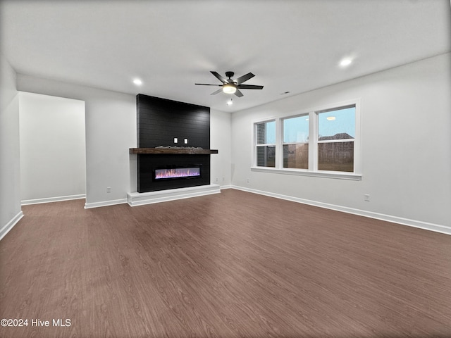 unfurnished living room featuring ceiling fan, a fireplace, and hardwood / wood-style flooring