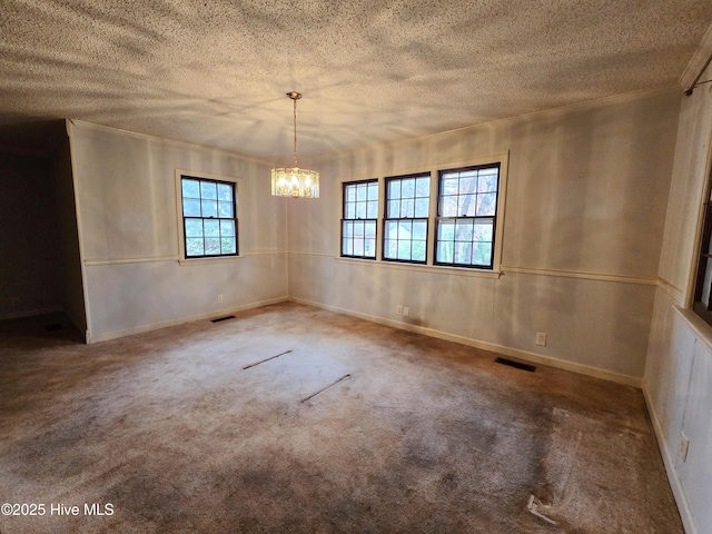 carpeted empty room featuring a textured ceiling, visible vents, and a notable chandelier