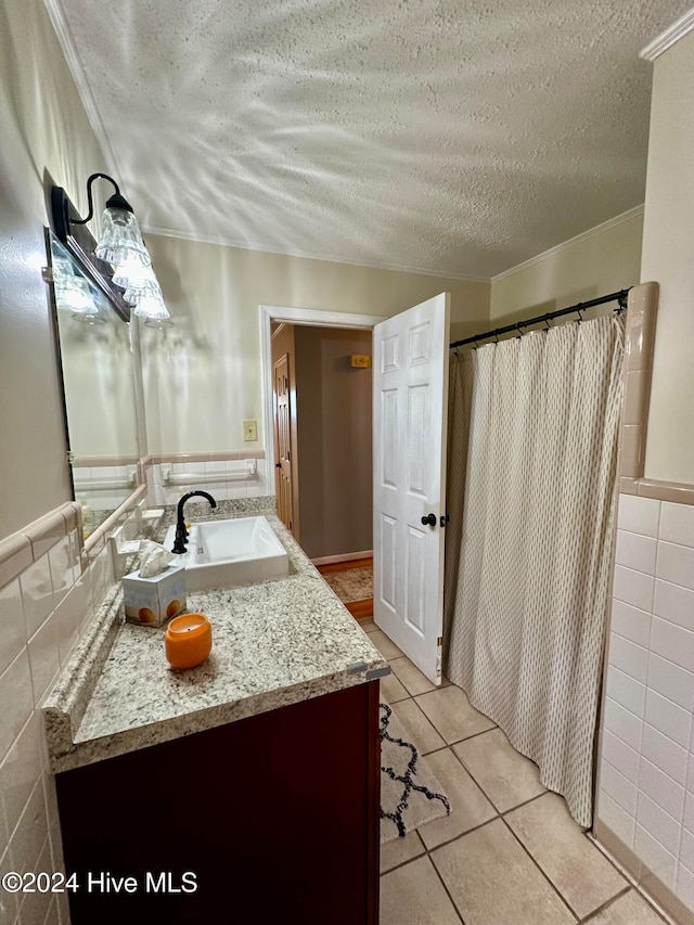 bathroom featuring a textured ceiling, vanity, tile walls, and tile patterned floors